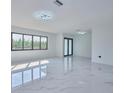 Spacious living room featuring abundant natural light and marble floors at 2310 Laguna Dr, Indian Lake Estates, FL 33855
