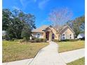 Beautiful single-story home showcasing a curved walkway, mature trees, and well-maintained lawn at 5685 Lake Victoria Dr, Lakeland, FL 33813
