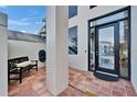 Welcoming front porch featuring tile flooring, stylish seating, and a modern front door at 616 Peninsular Dr, Lakeland, FL 33813