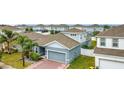 Side view of a lovely home featuring a well-kept lawn, a two-car garage, and lush landscaping at 648 Bloom Ter, Davenport, FL 33836