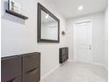 Inviting foyer featuring a large mirror, storage unit, and tile flooring near the entrance at 648 Bloom Ter, Davenport, FL 33836