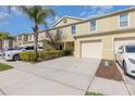 Townhome exterior with attached one-car garage and a well-manicured lawn at 380 Arbor Lakes Dr, Davenport, FL 33896
