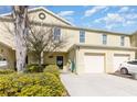 Yellow townhome exterior featuring a one car garage, lawn, and walkway to the front door at 380 Arbor Lakes Dr, Davenport, FL 33896