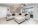Cozy living room with a gray sectional couch, ceiling fan, and sliding glass door to the backyard at 380 Arbor Lakes Dr, Davenport, FL 33896