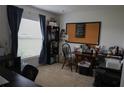 Bedroom features a bulletin board, natural light, and neutral colored carpet at 512 Central Ridge Ln, Frostproof, FL 33843