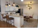 Modern kitchen featuring a breakfast bar, stainless steel appliances, and stylish pendant lighting at 992 Davit Pl, The Villages, FL 32162