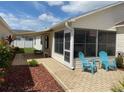 Inviting outdoor patio featuring screened enclosure, with comfortable seating and lush landscaping at 992 Davit Pl, The Villages, FL 32162