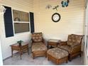 Enclosed outdoor patio seating area that features wicker seating, tables, and decorative wall art at 992 Davit Pl, The Villages, FL 32162