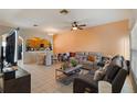 Inviting living room featuring tile floors, a ceiling fan, and comfortable seating at 12313 Citruswood Dr, Orlando, FL 32832