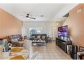 Bright living room featuring tile floors, a ceiling fan, and neutral decor at 12313 Citruswood Dr, Orlando, FL 32832
