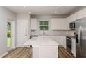 Bright kitchen with white cabinets, stainless steel appliances, island, and view to backyard at 5421 Sw 82Nd Ter, Ocala, FL 34481