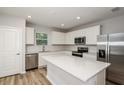 Modern kitchen features white cabinets, stainless steel appliances, and a center island with white countertop at 5421 Sw 82Nd Ter, Ocala, FL 34481