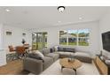 Bright living room featuring neutral decor, a sectional sofa, and large windows offering backyard views at 9009 Sw 52Nd Place Rd, Ocala, FL 34481