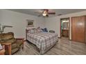 Cozy bedroom with a ceiling fan, wood-look flooring, and an ensuite bathroom at 10774 Sw 185Th Ter, Dunnellon, FL 34432