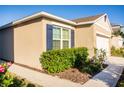 Exterior shot featuring a home with blue shutters and neatly trimmed bushes along the foundation at 469 Liu Ln, Deland, FL 32724