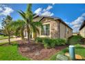 Well-kept home featuring stone accents, verdant landscaping, and a paver driveway leading to a two-car garage at 439 Toldedo Rd, Davenport, FL 33837