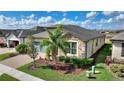 Well-kept home featuring stone accents, verdant landscaping, and a paver driveway leading to a two-car garage at 439 Toldedo Rd, Davenport, FL 33837
