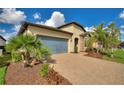 Well-kept home featuring stone accents, verdant landscaping, and a paver driveway leading to a two-car garage at 439 Toldedo Rd, Davenport, FL 33837