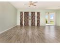 An open living room with tile floors, neutral walls, ceiling fan and sliding doors at 1006 Breggia Ct, Haines City, FL 33844