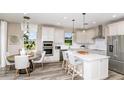 Bright kitchen with island seating, stainless steel appliances, pendant lighting, and adjacent dining area at 1671 Ruby Ln, Lake Alfred, FL 33850