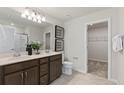 Well-lit bathroom with a double sink vanity, framed mirror and a separate door to the walk-in closet at 288 Woodsage Pl, Lake Alfred, FL 33850