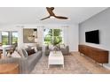 Bright living room featuring modern furniture, a ceiling fan and large windows offering natural light at 288 Woodsage Pl, Lake Alfred, FL 33850