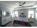 Serene main bedroom with tray ceiling, ceiling fan, and ample natural light for a relaxing retreat at 891 Galloway St, Lake Alfred, FL 33850