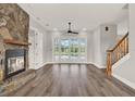 Spacious living room with wood floors, stone fireplace, and a wall of French doors leading to the pool area at 17416 Magnolia Island Blvd, Clermont, FL 34711