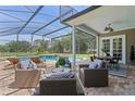 Relaxing screened patio area featuring comfortable wicker furniture and pool access at 17416 Magnolia Island Blvd, Clermont, FL 34711