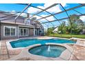 Screened-in pool area featuring a kidney shaped pool and integrated spa, all surrounded by brick pavers at 17416 Magnolia Island Blvd, Clermont, FL 34711