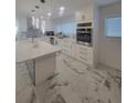 Well lit, modern, bright kitchen, complete with stainless steel appliances, quartz countertops, and an island at 1912 Providence Rd, Lakeland, FL 33805