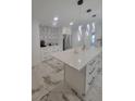 Bright, modern kitchen featuring stone tile flooring, an eat-in island, and pendant lights at 1912 Providence Rd, Lakeland, FL 33805