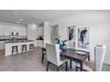 Open-concept dining area with modern decor, a dark wood table, and views of the kitchen at 705 Peroni Ave, Debary, FL 32713