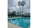 Community pool and deck area with lounge chairs and palm trees at 101 Bent Tree Dr # 12, Daytona Beach, FL 32114