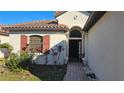 Inviting front entrance with arched doorway, red-tiled roof and beautiful landscaping at 315 Villa Sorrento Cir, Haines City, FL 33844