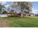 Spacious home featuring a well-maintained lawn, mature trees, and a welcoming facade at 1176 Balfour Dr, Deltona, FL 32725