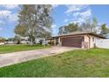 One-story home with a two-car garage, front lawn, and brick accents on a sunny day in a quiet neighborhood at 1176 Balfour Dr, Deltona, FL 32725