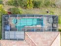 Aerial view of a screened-in pool and spa showcasing a serene backyard oasis with lounging area at 374 Villa Sorrento Cir, Haines City, FL 33844