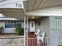 Inviting front porch featuring decorative railing, tile floor, and seating, enhancing curb appeal at 753 Avenue O Se, Winter Haven, FL 33880