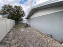 View of side yard with privacy fence, gravel, and outdoor air conditioning unit at 753 Avenue O Se, Winter Haven, FL 33880