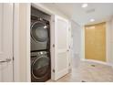 Hallway view showing stacked Samsung washer and dryer in a closet with tile flooring at 101 S Eola Dr # 813, Orlando, FL 32801