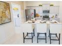 Modern kitchen featuring stainless steel appliances, gray cabinets, and a large center island with seating at 5888 Meditation Dr, Clermont, FL 34714