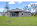 Expansive backyard featuring a covered patio and lush green lawn, perfect for outdoor activities at 409 Ashbury Way, Poinciana, FL 34759