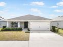 Charming single Gathering home featuring a two car garage, beautiful landscaping and a concrete driveway at 653 Vittorio Dr, Winter Haven, FL 33884