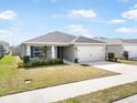 Charming single Gathering home featuring a two car garage, beautiful landscaping and a concrete driveway at 653 Vittorio Dr, Winter Haven, FL 33884