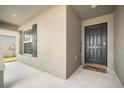 A welcoming front entryway with an elegant dark front door, a 'hello' door mat, and decorative window shutters at 653 Vittorio Dr, Winter Haven, FL 33884