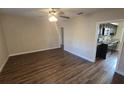 Open living room featuring a ceiling fan and wood-look floors, seamlessly connecting to the kitchen at 1804 S Mellonville Ave, Sanford, FL 32771