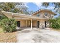 Beige two-story home showcases a covered carport and a manicured front yard at 819 22Nd Nw St, Winter Haven, FL 33881