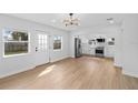 Open living area showcasing new floors and a stylish light fixture, seamlessly connected to a modern kitchen at 2015 Poe St, Lakeland, FL 33801