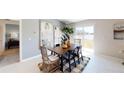 Inviting dining area with wood table, modern chairs, rug, and sliding glass doors to water views at 4765 Golden Knight Blvd, Kissimmee, FL 34746